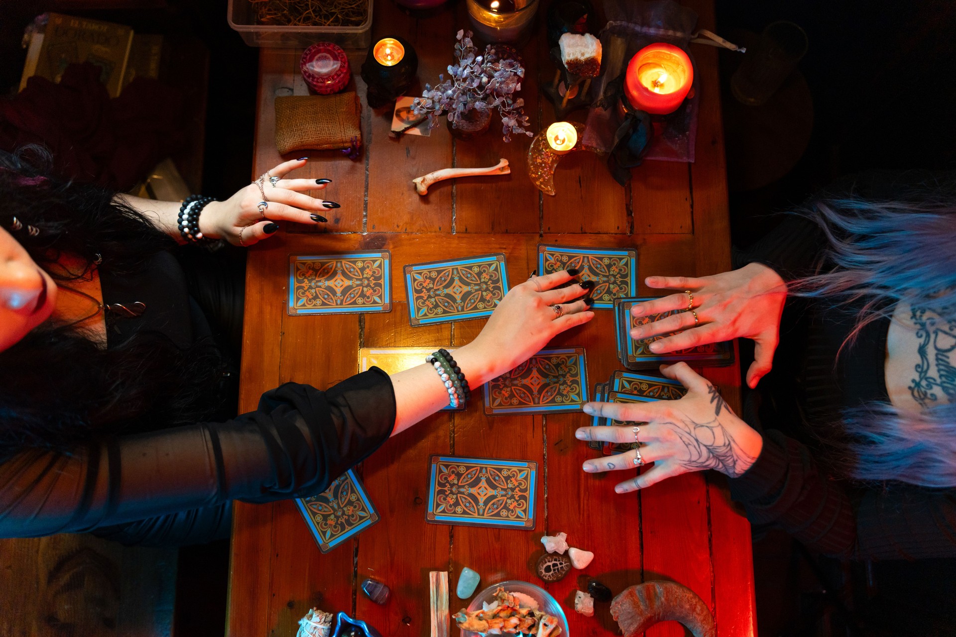 Fortune teller reading tarot cards on wooden table with candles Fortune teller reading tarot cards on wooden table with candles